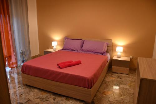 a bedroom with a bed with a red pillow on it at La Contessa Apartment in Palermo