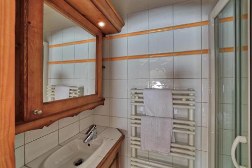 La salle de bains est pourvue d'un lavabo et d'un miroir. dans l'établissement Chalet Etoiles - Les Chalets des Etoiles, à Chamonix-Mont-Blanc
