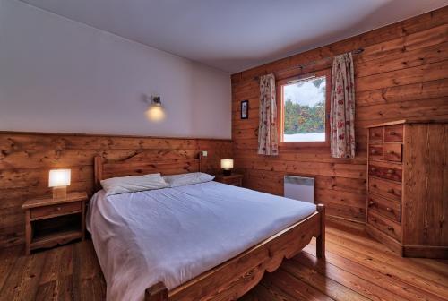 シャモニー・モンブランにあるChalet Etoiles - Les Chalets des Etoilesのベッドルーム1室(ベッド1台、窓、木製の壁付)
