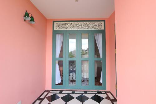 a room with a blue door in a pink room at Hiranyakul House in Bangkok
