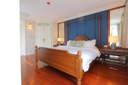 a bedroom with a bed with a blue wall at Hiranyakul House in Bangkok