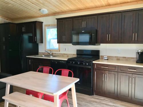 a kitchen with black cabinets and a table with red chairs at Fairmont Hot Springs Resort in Fairmont Hot Springs
