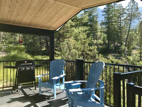 a deck with blue chairs and a grill at Fairmont Hot Springs Resort in Fairmont Hot Springs