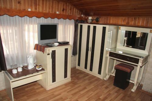 uma sala de estar com televisão e uma mesa com televisão em Zeynep Hanim Konagi em Gaziantep