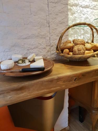 a table with a basket of bread and cheese at Hotel zum Goldenen Wagen in Maulburg