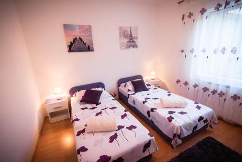a bedroom with two beds and a window at Ivano Apartments in Grebaštica