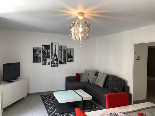 a living room with a couch and a chandelier at Dream Apartments in Serris