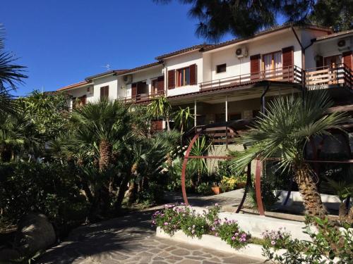 a building with palm trees in front of it at Eden Park Hotel in Marina di Campo
