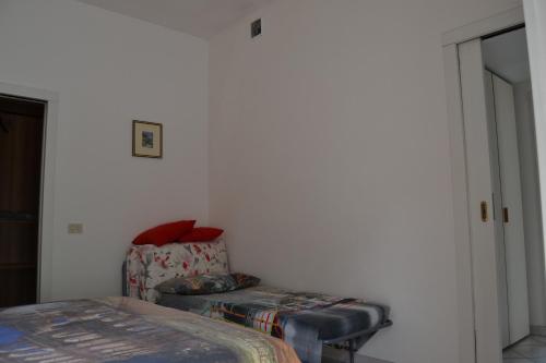 a bedroom with a bed and a chair in a room at Appartamenti Lago di Como in Valbrona