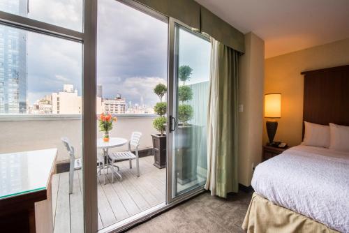 Cette chambre d'hôtel comprend un lit et un balcon. dans l'établissement SoHo 54, à New York