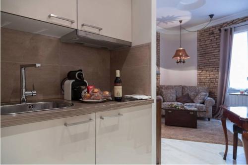 a kitchen with a sink and a table with a bottle of wine at Apartamento en Casco Antiguo in Logroño