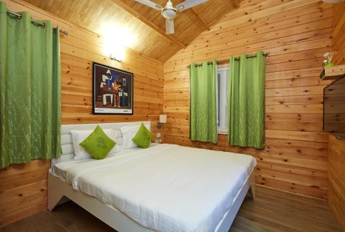 1 dormitorio con 1 cama en una habitación de madera en Bodhiwoods Resorts en Mahabalipuram
