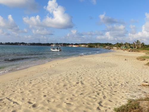 a boat in the water on a beach at Paraiso Beach Hotel in Big Corn Island