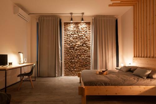 um quarto com uma cama e uma parede de pedra em Artisan Home em Bérgamo