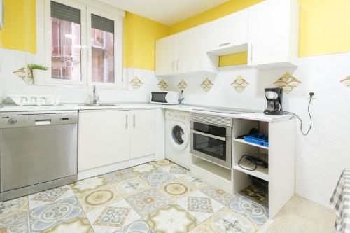 a kitchen with white cabinets and a dishwasher at Edificio 10 by Plaza Mayor Apartamentos in Valladolid