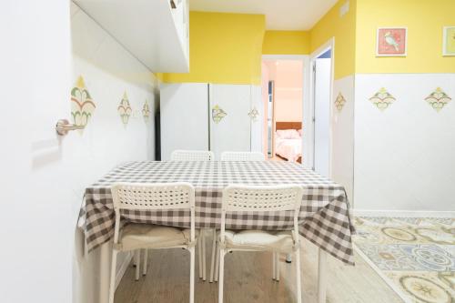 a dining room with a checkered table and chairs at Edificio 10 by Plaza Mayor Apartamentos in Valladolid