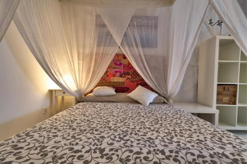 a bedroom with a bed with a canopy at Edificio 10 by Plaza Mayor Apartamentos in Valladolid
