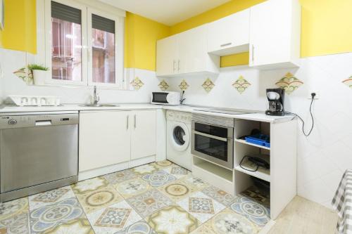 a kitchen with a sink and a dishwasher at Edificio 10 by Plaza Mayor Apartamentos in Valladolid