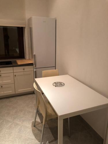 a kitchen with a white table and a refrigerator at Rana's Zimmervermittlung in Bremen
