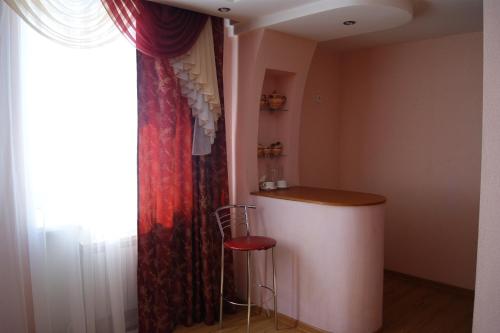 een kamer met een aanrecht en een kruk naast een raam bij Triumph Hotel in Rudny