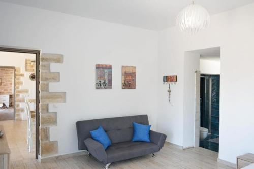 a living room with a gray couch and blue pillows at Villa Petra in Kamilari