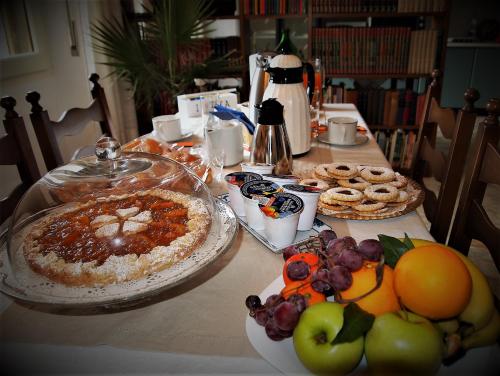 een tafel vol eten en fruit op een tafel bij Superpanoramico in Cagliari