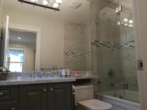 Un baño con ducha, lavabo e inodoro. en White Rose House, en White Rock