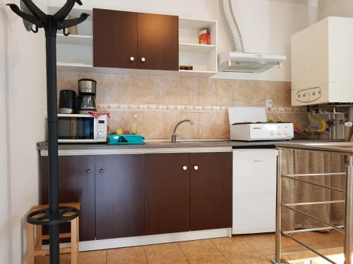 een keuken met bruine kasten en een wastafel bij Vivaldi Studios in Cluj-Napoca