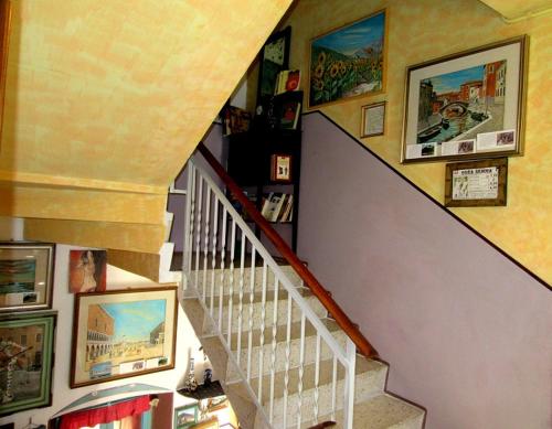 a staircase in a house with pictures on the wall at Art B&B La Casa del Pittore in Revine Lago