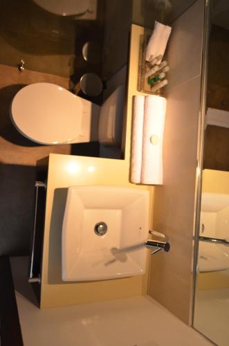 a small bathroom with a toilet and a sink at Hotel Gran Mariscal Quito in Quito