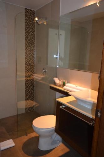 a bathroom with a toilet and a sink and a shower at Hotel Gran Mariscal Quito in Quito