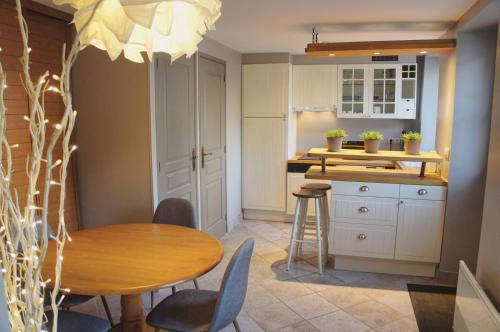 a kitchen with a table and chairs and a counter at Corps de ferme restauré proche Barbizon in Saint-Martin-en-Bière