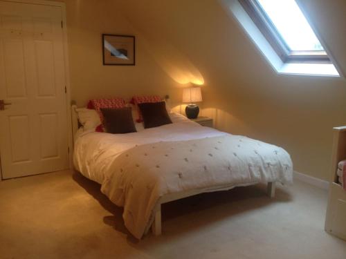 a bedroom with a large bed with a window at Chalkcroft Lodge in Andover