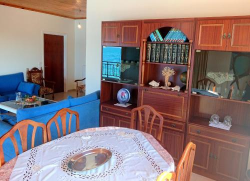 jadalnia ze stołem i niebieską kanapą w obiekcie xanthi's sea front villas w mieście Flámbouras