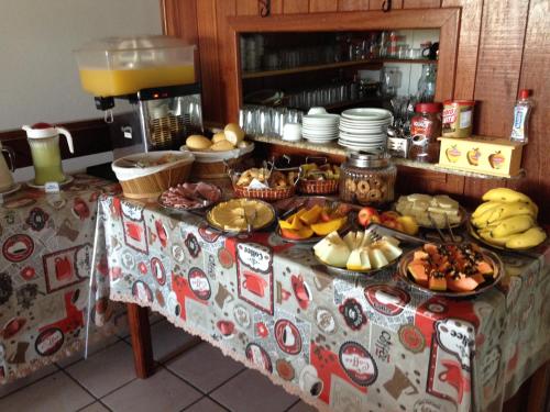 ein Tisch mit einem Buffet mit Speisen darauf in der Unterkunft Pousada Sol da Ferrugem in Garopaba