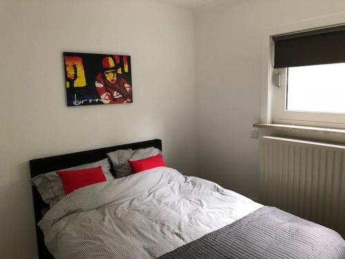 een bed met twee rode kussens in een slaapkamer bij Appartement BBwB in Breda