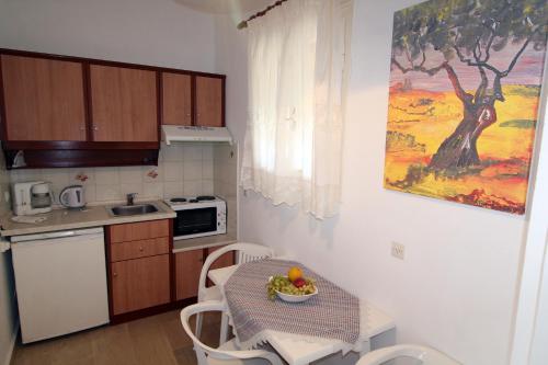 a kitchen with a table with a bowl of fruit on it at House Dimitri Agios Georgios Pagoi Corfu in Agios Georgios Pagon