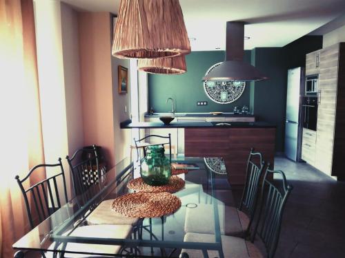 a kitchen with a glass table with chairs and a counter at Apartmento Obispo Rocamora in Orihuela