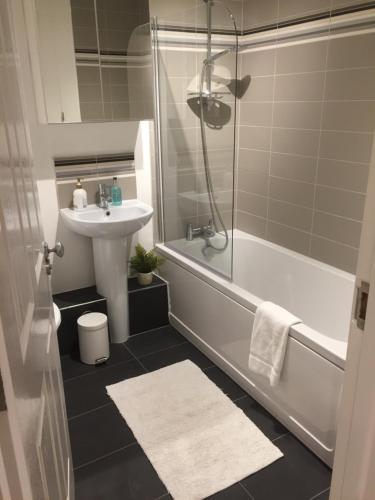 a bathroom with a tub and a sink and a shower at City Centre Belfast Free Parking in Belfast