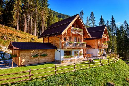 una casa de madera con una valla delante en Chalets Almidylle, en Sankt Martin am Tennengebirge