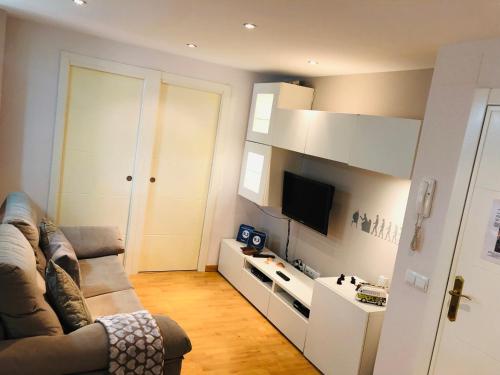 Il comprend un salon doté d'un canapé et d'une télévision à écran plat. dans l'établissement Apartamento Malagueta, à Malaga