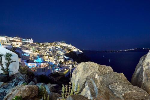 a view of a city from a cliff at night at Villa Etheras in Firostefani