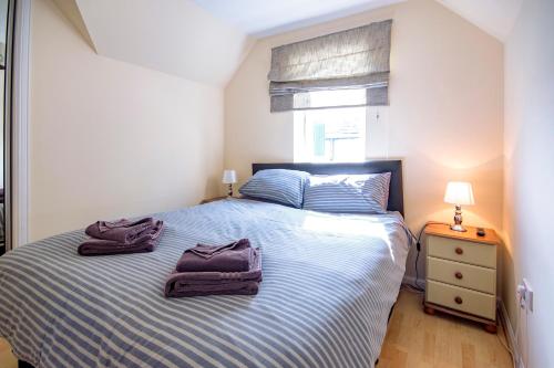 a bedroom with a bed with two towels on it at 7 Varis Apartments in Forres