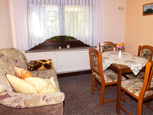 ein Wohnzimmer mit einem Tisch und einem Sofa sowie einem Tisch und Stühlen in der Unterkunft FH Schmidt in Hohnstein