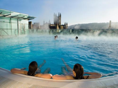 a group of people swimming in a hot tub in a geothermal spa at Park View Two-Bedroom Apartment in Bath