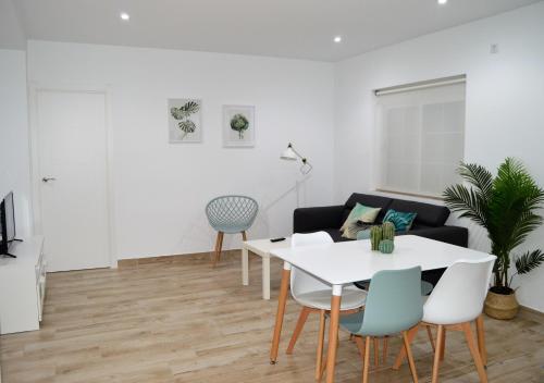 a living room with a white table and chairs at Nova Domus Apartamentos in Mérida