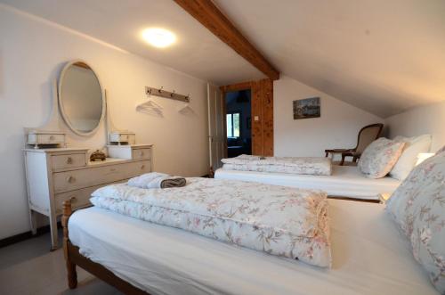 a bedroom with two beds and a dresser and a mirror at Mountain Views in Interlaken