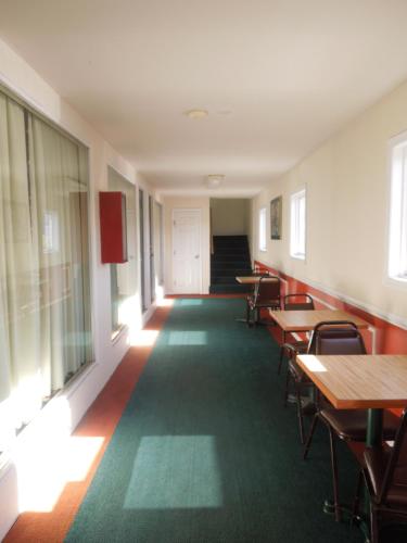 an empty room with tables and chairs and a door at Value Inn East Stroudsburg in Marshalls Creek