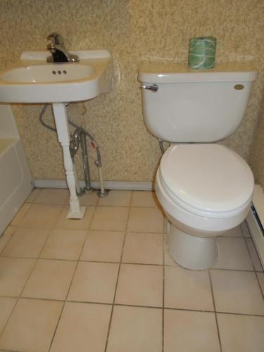 a bathroom with a toilet and a sink at Value Inn East Stroudsburg in Marshalls Creek