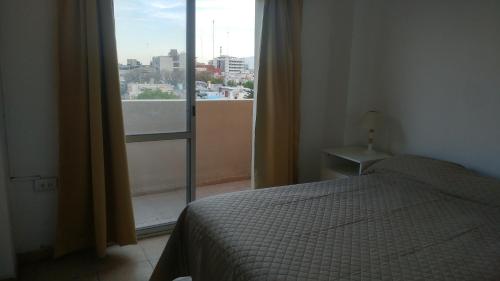 a bedroom with a bed and a large window at Departamento en pleno centro de San Juan in San Juan
